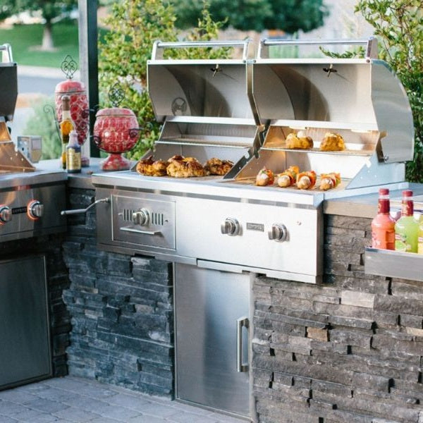 Coyote C3HY50 50-inch stainless steel hybrid gas and charcoal grill with multiple cooking zones and control knobs.