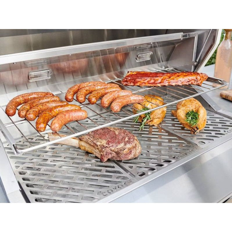Coyote C2P28 28-inch stainless steel pellet grill with built-in design, featuring a lid and control panel for outdoor cooking.