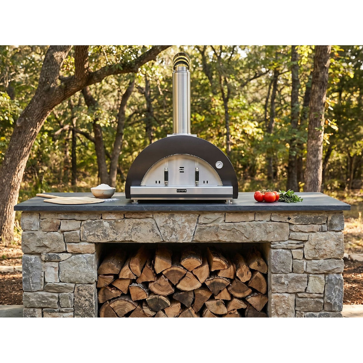 Coyote C1PZ40WMB 40-inch matte black outdoor wood-fired pizza oven with a spacious cooking chamber and pizza peel.